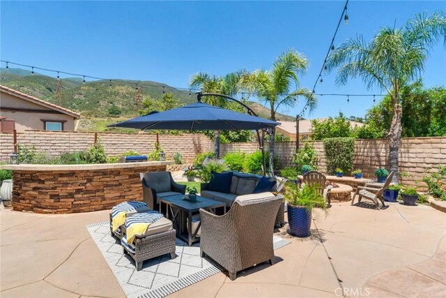4765 Falconview Ct, Fontana, CA 92336 - fenced backyard featuring outdoor lounge area, a patio, and a mountain view