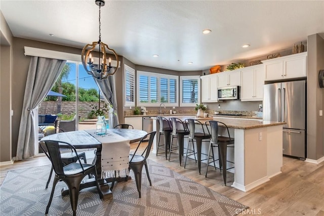 4765 Falconview Ct, Fontana, CA 92336 - dining space with a chandelier, light wood-type flooring, and recessed lighting