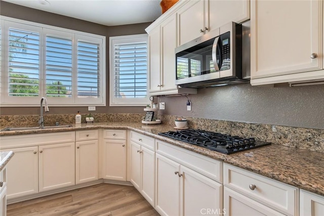 4765 Falconview Ct, Fontana, CA 92336 - kitchen featuring stainless steel microwave, black gas cooktop, plenty of natural light, and light wood-type flooring