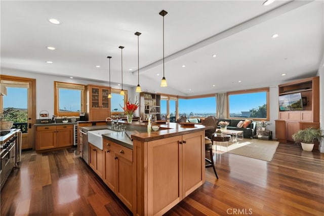624 6th St, Manhattan Beach, CA 90266 - kitchen with dark wood finished floors, dark countertops, an island with sink, recessed lighting, and a breakfast bar area