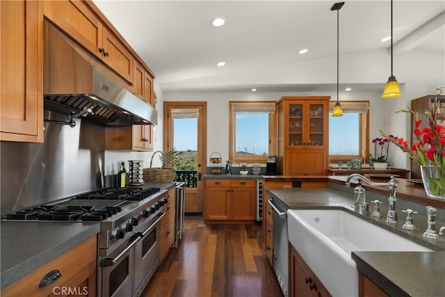 624 6th St, Manhattan Beach, CA 90266 - kitchen with stainless steel appliances, under cabinet range hood, dark countertops, brown cabinets, and hanging light fixtures
