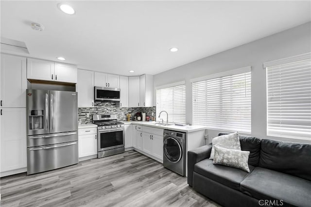 518 Hawthorne St, Glendale, CA 91204 - kitchen featuring stainless steel appliances, washer / clothes dryer, a sink, light countertops, and white cabinetry