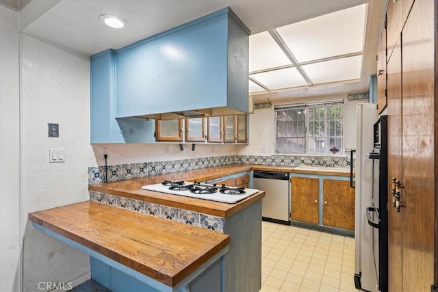 895 Huston Dr, Riverside, CA 92507 - kitchen featuring dishwasher, white gas cooktop, a peninsula, a textured wall, and glass insert cabinets