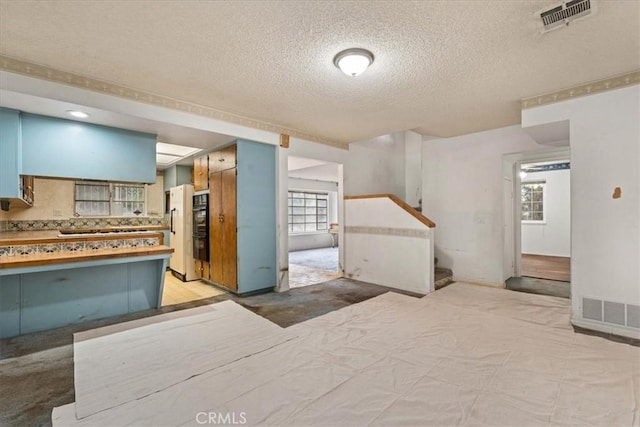 895 Huston Dr, Riverside, CA 92507 - kitchen with freestanding refrigerator, a textured ceiling, healthy amount of natural light, and light carpet