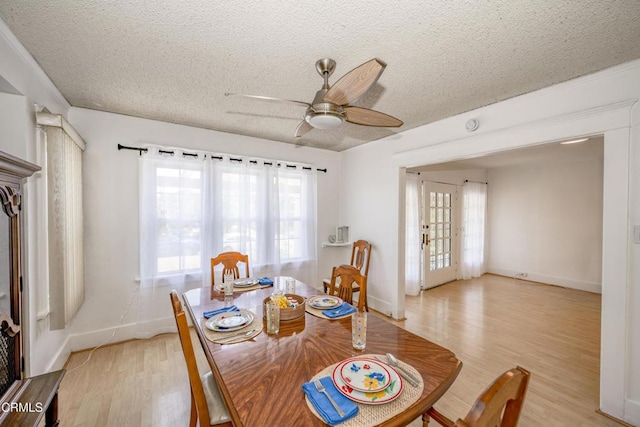 1139 N Heliotrope Dr, Los Angeles, CA 90029 - dining space featuring a textured ceiling, plenty of natural light, light wood-style floors, and a ceiling fan