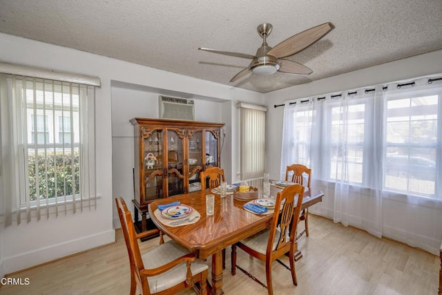 1139 N Heliotrope Dr, Los Angeles, CA 90029 - dining room featuring light wood finished floors, ceiling fan, a textured ceiling, baseboards, and a wall unit AC