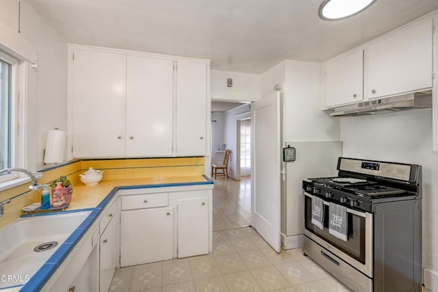 1139 N Heliotrope Dr, Los Angeles, CA 90029 - kitchen featuring stainless steel range with gas stovetop, under cabinet range hood, a sink, white cabinetry, and decorative backsplash