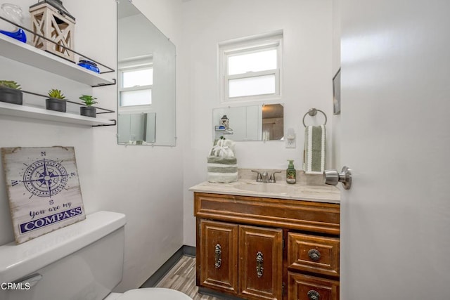 1139 N Heliotrope Dr, Los Angeles, CA 90029 - bathroom featuring toilet, vanity, wood finished floors, and baseboards