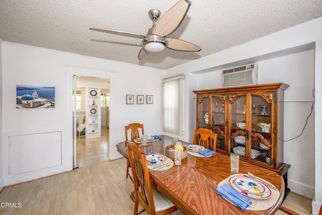 1139 N Heliotrope Dr, Los Angeles, CA 90029 - dining room featuring a textured ceiling, a ceiling fan, an AC wall unit, and light wood-style floors
