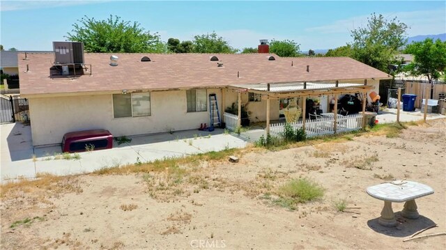 39313 168th St E, Palmdale, CA 93591 - back of property featuring a chimney, stucco siding, and a patio area