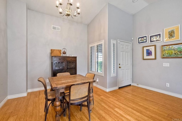 1208 Sunglow Dr, Oceanside, CA 92056 - dining area with a chandelier, light wood-style floors, baseboards, and a towering ceiling