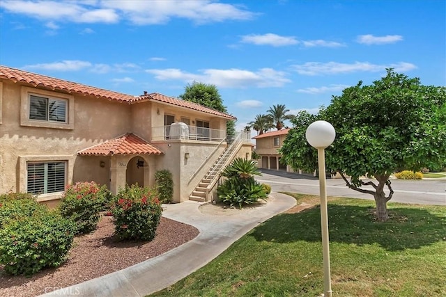 72864 Roy Emerson Ln, Palm Desert, CA 92260 - view of front of house featuring stairway, stucco siding, a front yard, and a tiled roof