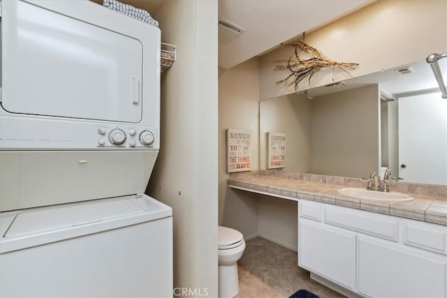 72864 Roy Emerson Ln, Palm Desert, CA 92260 - bathroom with stacked washer / drying machine, vanity, toilet, tile patterned flooring, and baseboards