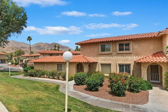 72864 Roy Emerson Ln, Palm Desert, CA 92260 - mediterranean / spanish home featuring a mountain view, a front lawn, a tile roof, and stucco siding