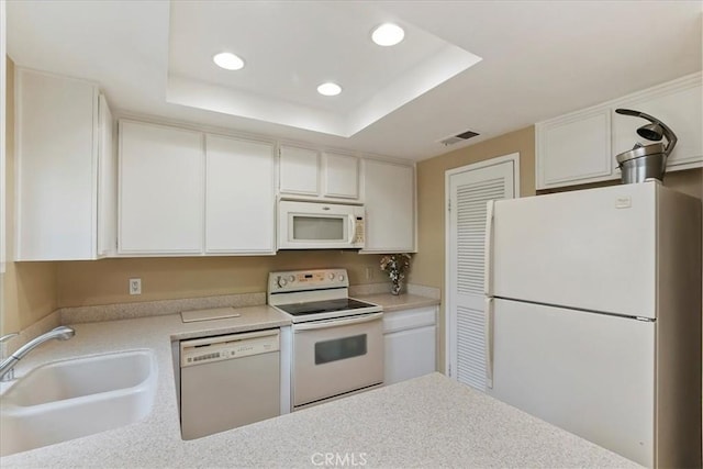 72864 Roy Emerson Ln, Palm Desert, CA 92260 - kitchen featuring white appliances, a sink, a tray ceiling, recessed lighting, and light countertops