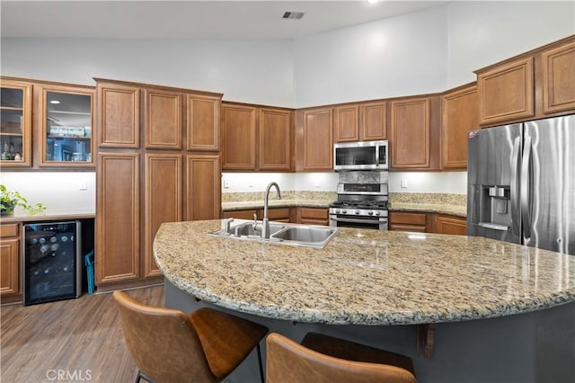 6662 W W Ave L4, Lancaster, CA 93536 - kitchen featuring appliances with stainless steel finishes, wine cooler, a sink, high vaulted ceiling, and brown cabinets