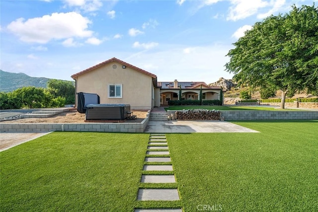 23592 Beech St, Hemet, CA 92545 - back of house with a hot tub, a lawn, stucco siding, and a mountain view