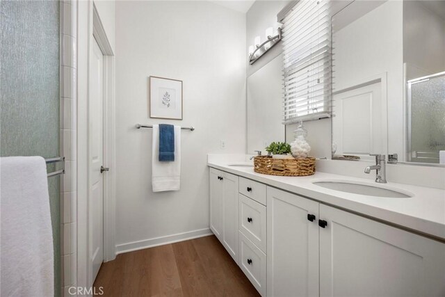 144 Borrego, Irvine, CA 92618 - full bath featuring double vanity, an enclosed shower, wood finished floors, and baseboards