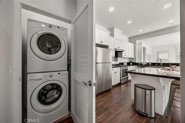 144 Borrego, Irvine, CA 92618 - washroom featuring estacked washer and dryer, dark wood-style floors, and recessed lighting
