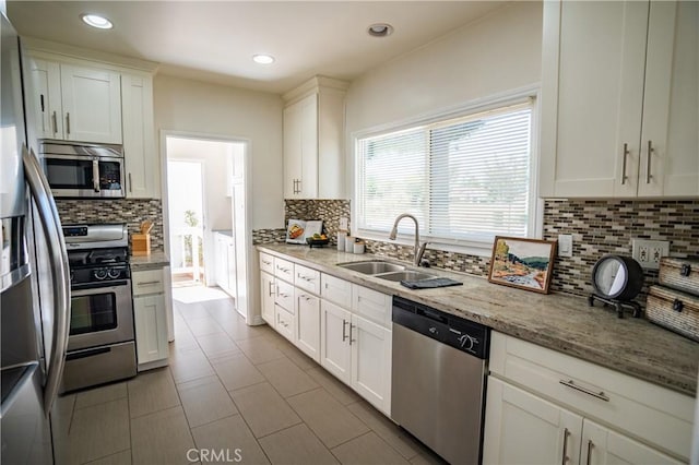 2691 Golden Ave, Long Beach, CA 90806 - kitchen with stainless steel appliances, a sink, backsplash, white cabinets, and light stone counters
