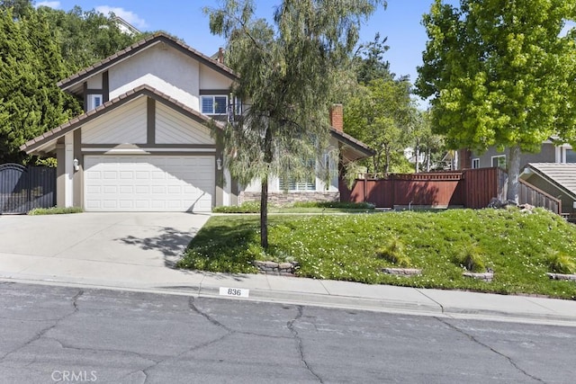 836 Via Alameda, San Dimas, CA 91773 - view of property hidden behind natural elements featuring stucco siding, driveway, and a garage