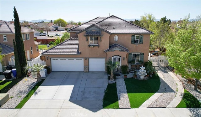 15541 Bow String St, Victorville, CA 92394 - view of front of home with stucco siding, concrete driveway, a tiled roof, a gate, and a garage