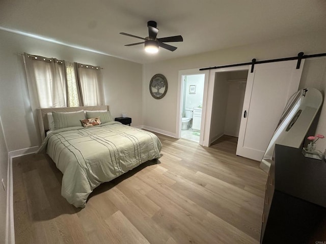 2453 Curlew St, San Diego, CA 92101 - bedroom featuring a barn door, light wood-style floors, baseboards, ensuite bathroom, and ceiling fan