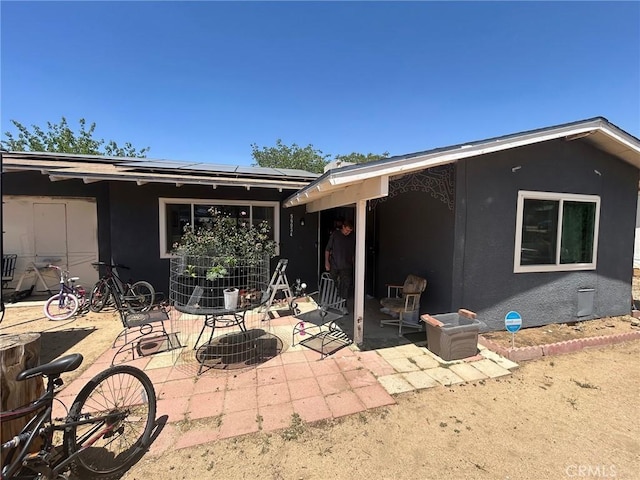 56034 Navajo Trl, Yucca Valley, CA 92284 - back of house featuring a patio area, solar panels, and stucco siding