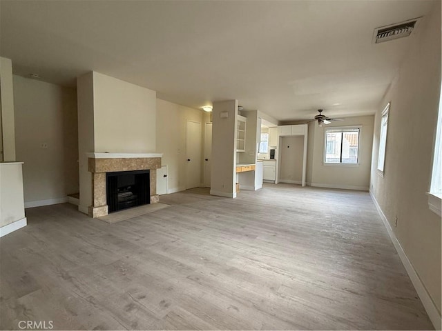 1701 Garvey Ave Unit 9, Alhambra, CA 91803 - unfurnished living room featuring a ceiling fan, light wood-style flooring, baseboards, and a tiled fireplace