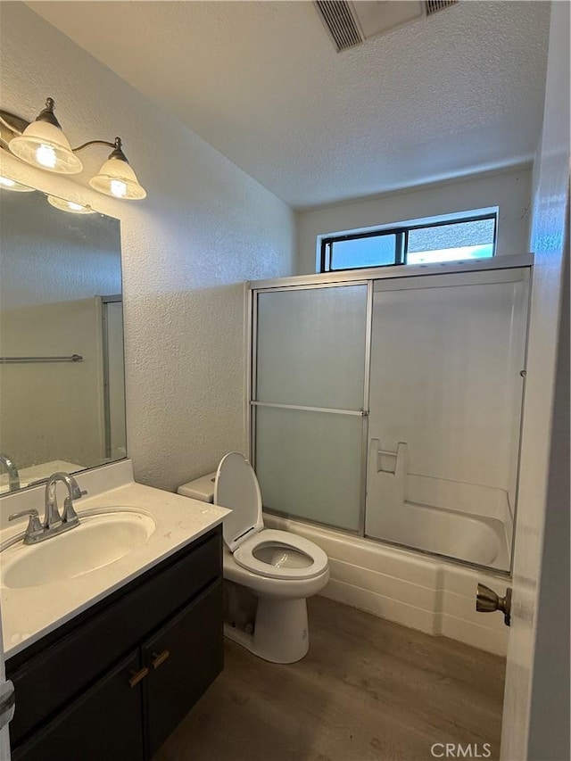 1701 Garvey Ave Unit 9, Alhambra, CA 91803 - bathroom featuring a textured wall, toilet, wood finished floors, vanity, and shower / bath combination with glass door