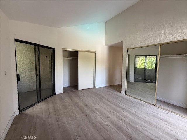1701 Garvey Ave Unit 9, Alhambra, CA 91803 - unfurnished bedroom with wood finished floors, vaulted ceiling, baseboards, and two closets
