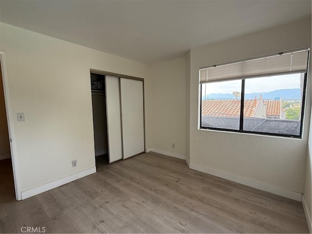 1701 Garvey Ave Unit 9, Alhambra, CA 91803 - unfurnished bedroom featuring light wood finished floors, baseboards, and a closet