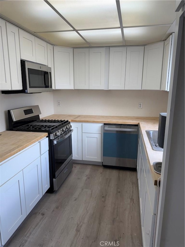 1701 Garvey Ave Unit 9, Alhambra, CA 91803 - kitchen featuring appliances with stainless steel finishes, light wood finished floors, white cabinets, and butcher block countertops