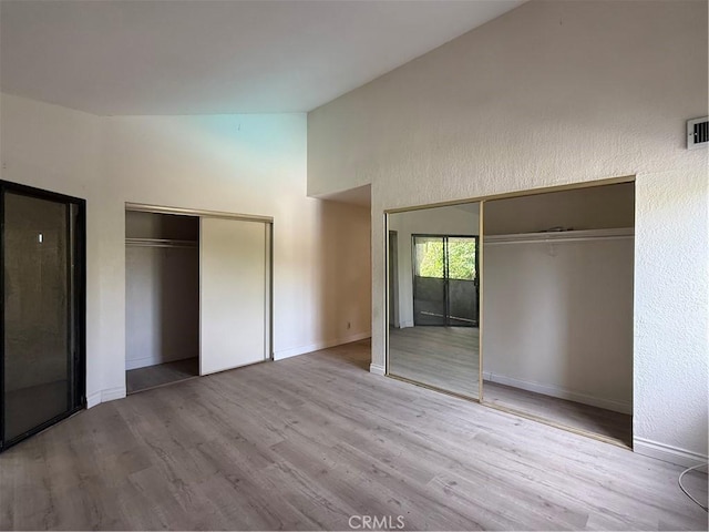 1701 Garvey Ave Unit 9, Alhambra, CA 91803 - unfurnished bedroom with wood finished floors, baseboards, two closets, and high vaulted ceiling