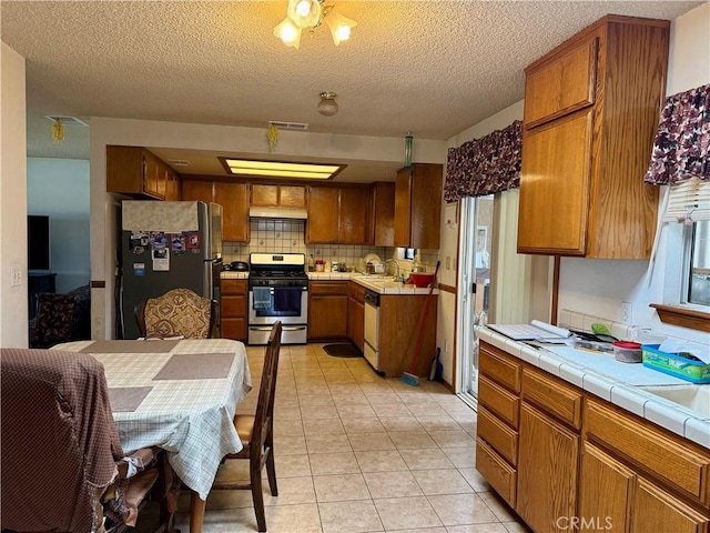 17798 Cherry St, Hesperia, CA 92345 - kitchen featuring stainless steel appliances, a sink, tasteful backsplash, brown cabinets, and light tile patterned flooring