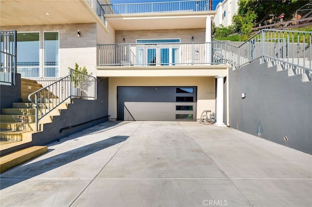 11837 Rideout Way, Whittier, CA 90601 - rear view of house featuring stairs, a balcony, concrete driveway, a garage, and brick siding