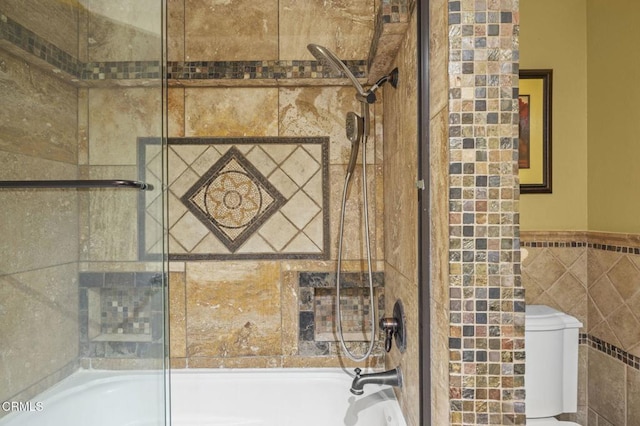 1099 N Agusta Ave, Camarillo, CA 93010 - bathroom view of bath / shower combo with glass door, tile walls, toilet, and a wainscoted wall