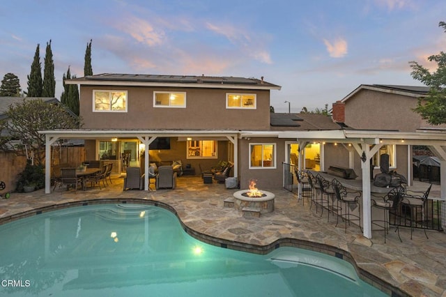 1099 N Agusta Ave, Camarillo, CA 93010 - back of house featuring a fire pit, a patio, stucco siding, and roof mounted solar panels