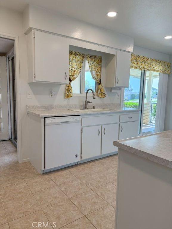 25620 Cherry Hills Blvd, Menifee, CA 92586 - kitchen with dishwasher, a sink, light countertops, light tile patterned floors, and white cabinetry