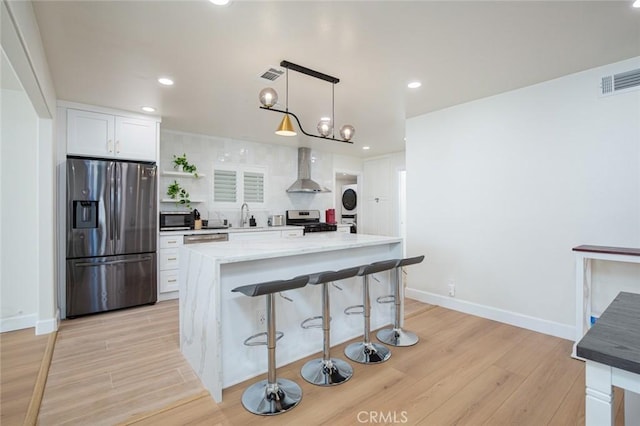 5911 Jones Ave, Westminster, CA 92683 - kitchen with stainless steel appliances, wall chimney range hood, light wood finished floors, white cabinetry, and recessed lighting