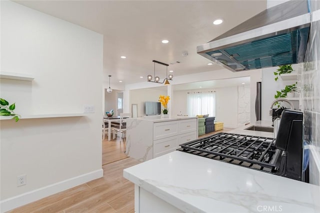 5911 Jones Ave, Westminster, CA 92683 - kitchen featuring extractor fan, light wood finished floors, white cabinetry, light stone countertops, and a sink