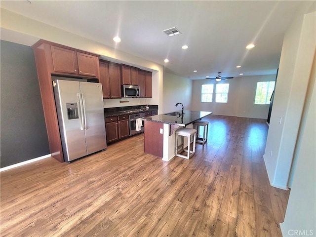 40955 Belleray Ave, Murrieta, CA 92562 - kitchen with stainless steel appliances, open floor plan, light wood-style floors, a kitchen breakfast bar, and recessed lighting