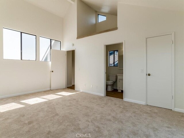 1311 15th St, Los Osos, CA 93402 - unfurnished bedroom featuring carpet floors, multiple windows, high vaulted ceiling, and ensuite bathroom