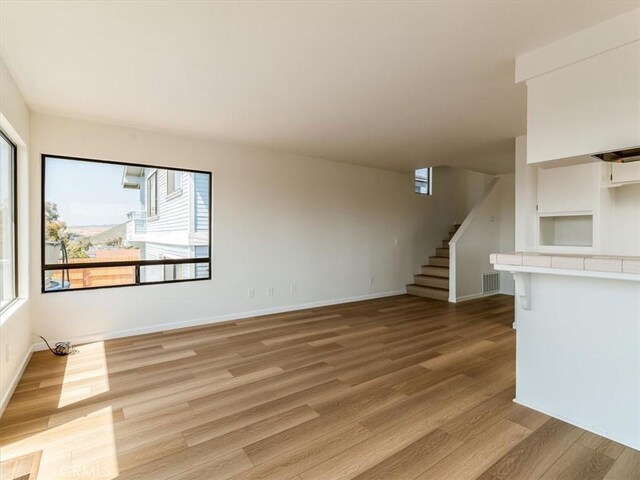 1311 15th St, Los Osos, CA 93402 - unfurnished living room with light wood-type flooring and stairway