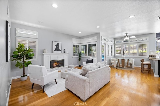 2300 Meadow View Ln, Chino Hills, CA 91709 - living room with baseboards, a glass covered fireplace, light wood-style flooring, a ceiling fan, and recessed lighting