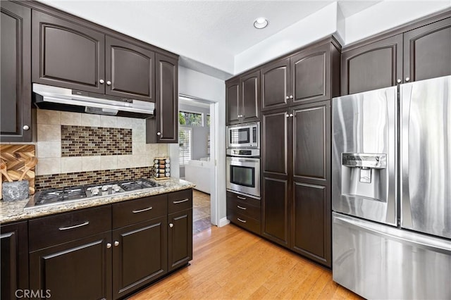 2300 Meadow View Ln, Chino Hills, CA 91709 - kitchen with stainless steel appliances, under cabinet range hood, dark brown cabinetry, backsplash, and recessed lighting