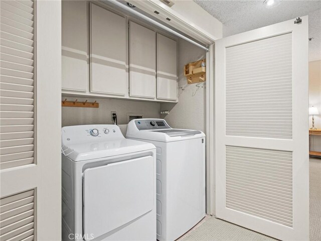 2563 Plaza Del Amo Unit 312, Torrance, CA 90503 - laundry area with cabinet space, washing machine and clothes dryer, and a textured ceiling