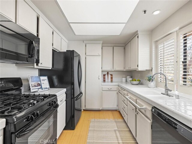 2563 Plaza Del Amo Unit 312, Torrance, CA 90503 - kitchen featuring black appliances, a sink, light wood-type flooring, white cabinetry, and recessed lighting