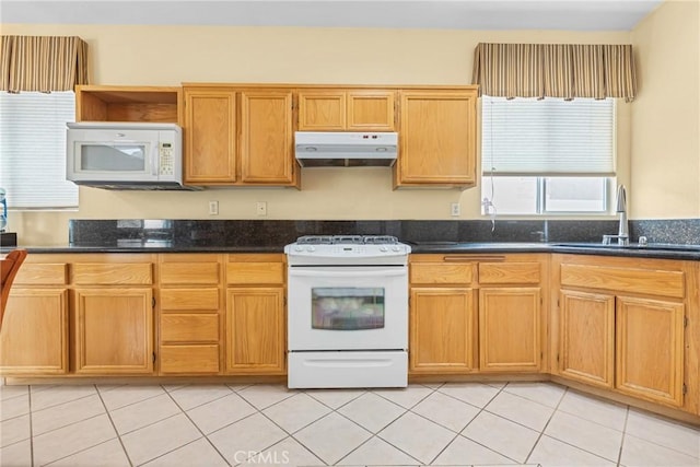 26835 Eclipse Dr, Menifee, CA 92585 - kitchen with white appliances, under cabinet range hood, a sink, light tile patterned floors, and dark stone countertops