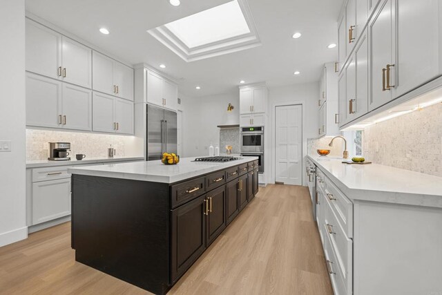 18150 Via Ascenso, Rancho Santa Fe, CA 92067 - kitchen with stainless steel appliances, light wood-style flooring, a kitchen island, tasteful backsplash, and recessed lighting